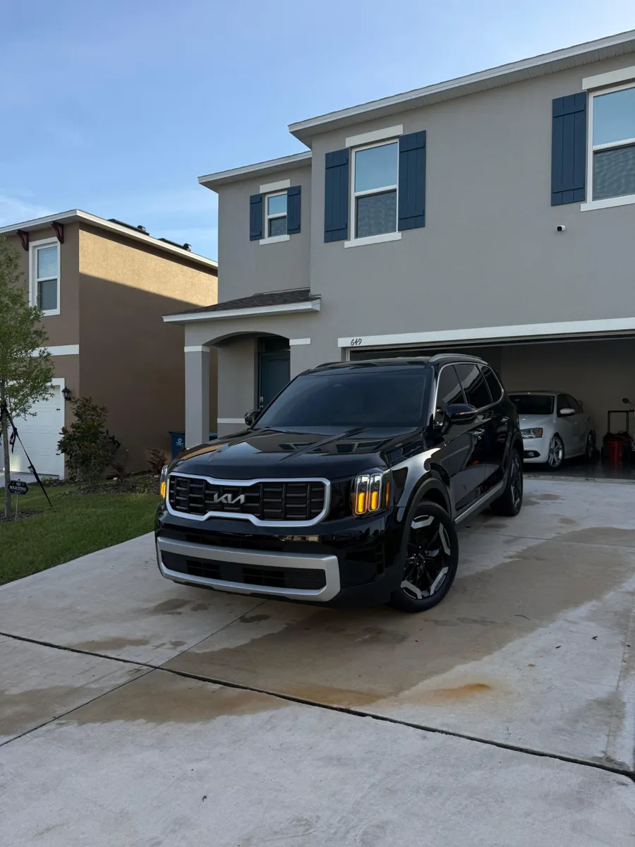 Black Kia SUV in a driveway after mobile detailing