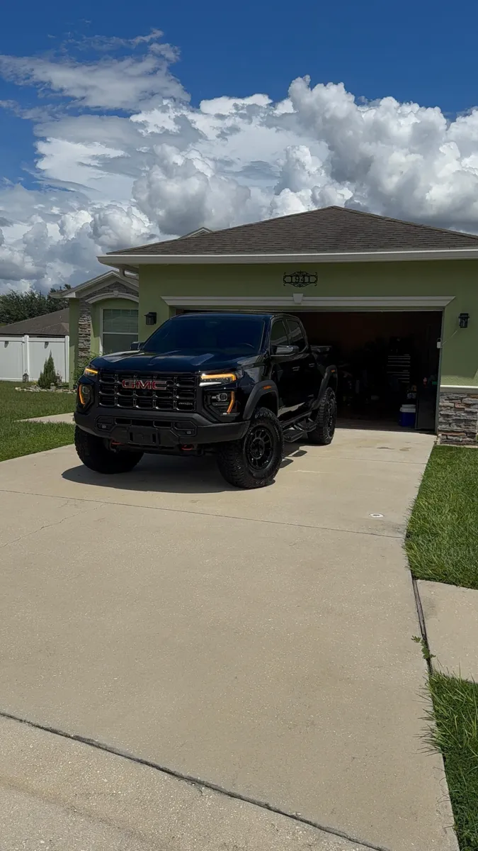 Black GMC pickup truck in a driveway after mobile detailing