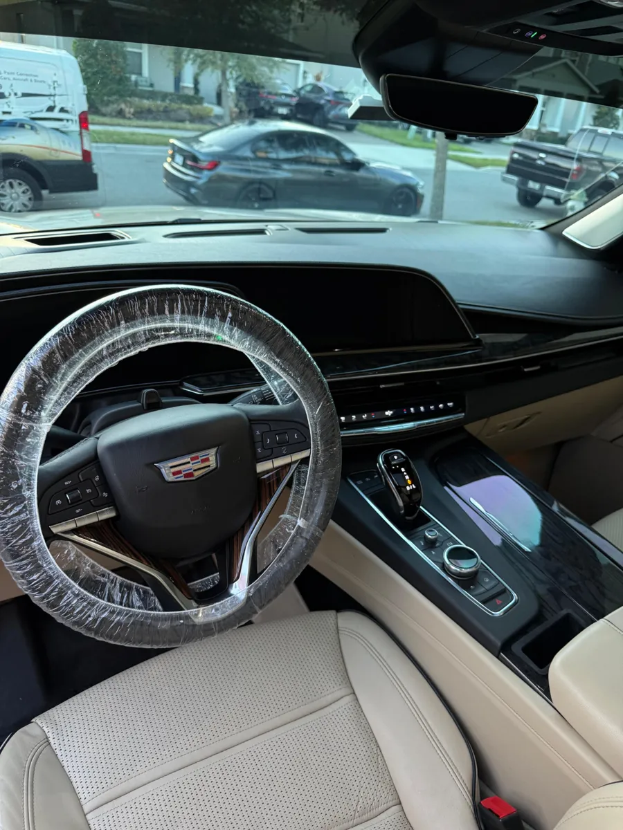 Detailed Cadillac interior with cleaned light leather seats and dashboard