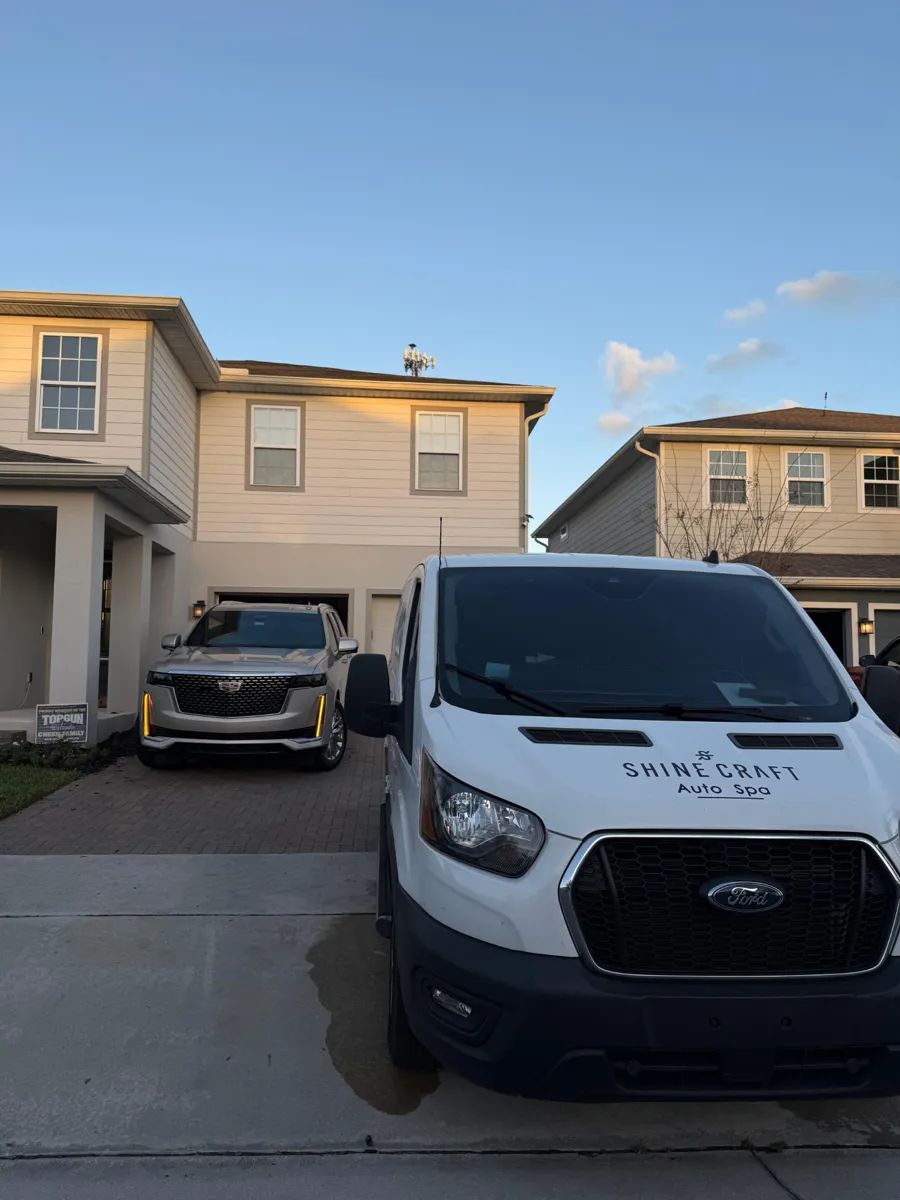 Shine Craft Auto Spa service van parked beside a customer's SUV in a driveway