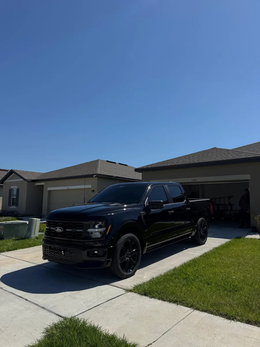 Black Ford pickup truck in a driveway after mobile detailing